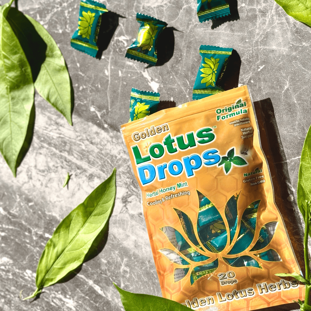 Golden Lotus Original Herbal Honey Mint Throat Lozenges displayed with individual drops and fresh herbal leaves, showcasing natural ingredients and refreshing sore throat relief.